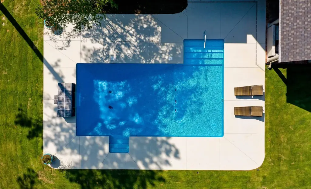 L-shaped pool with the shadows of nearby trees falling across the water